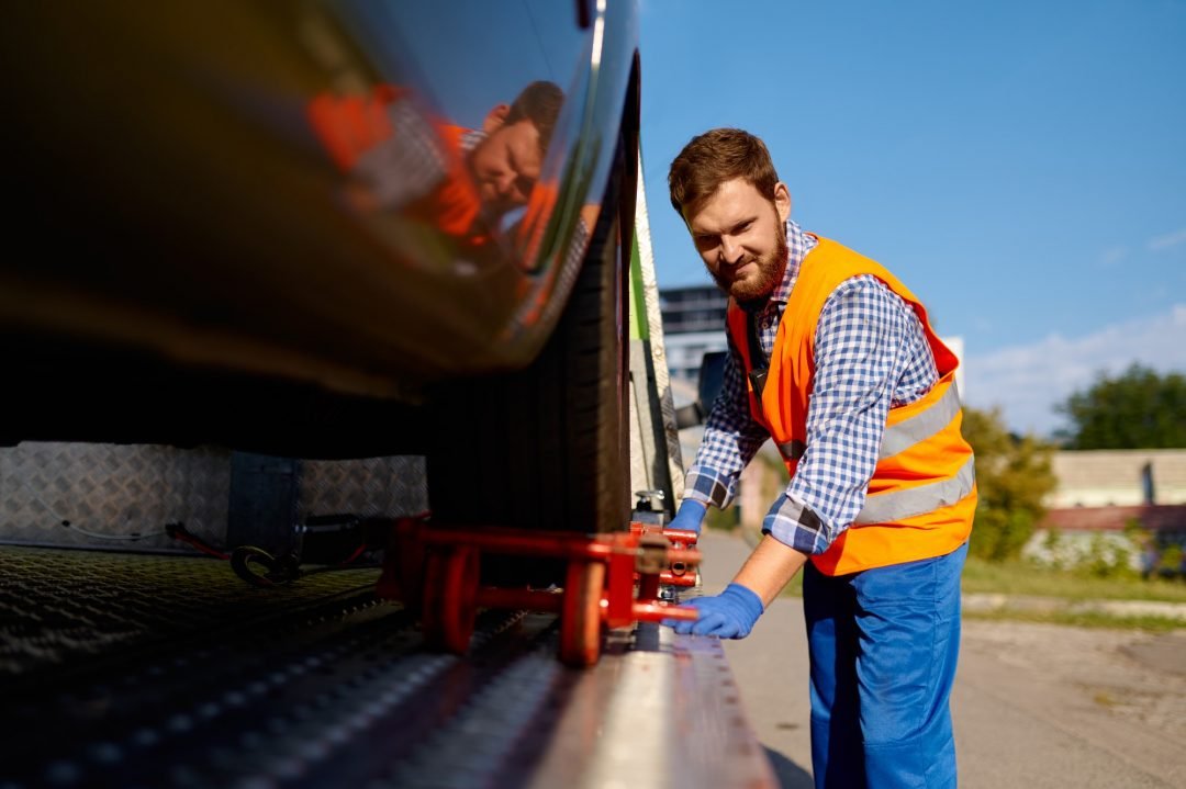 Tow operator securing a vehicle on the platform